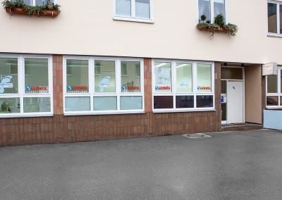 Eingangsbereich der Podologischen Praxis Rössler mit Parkplätzen vor der Fensterfront in Stuttgart Giebel